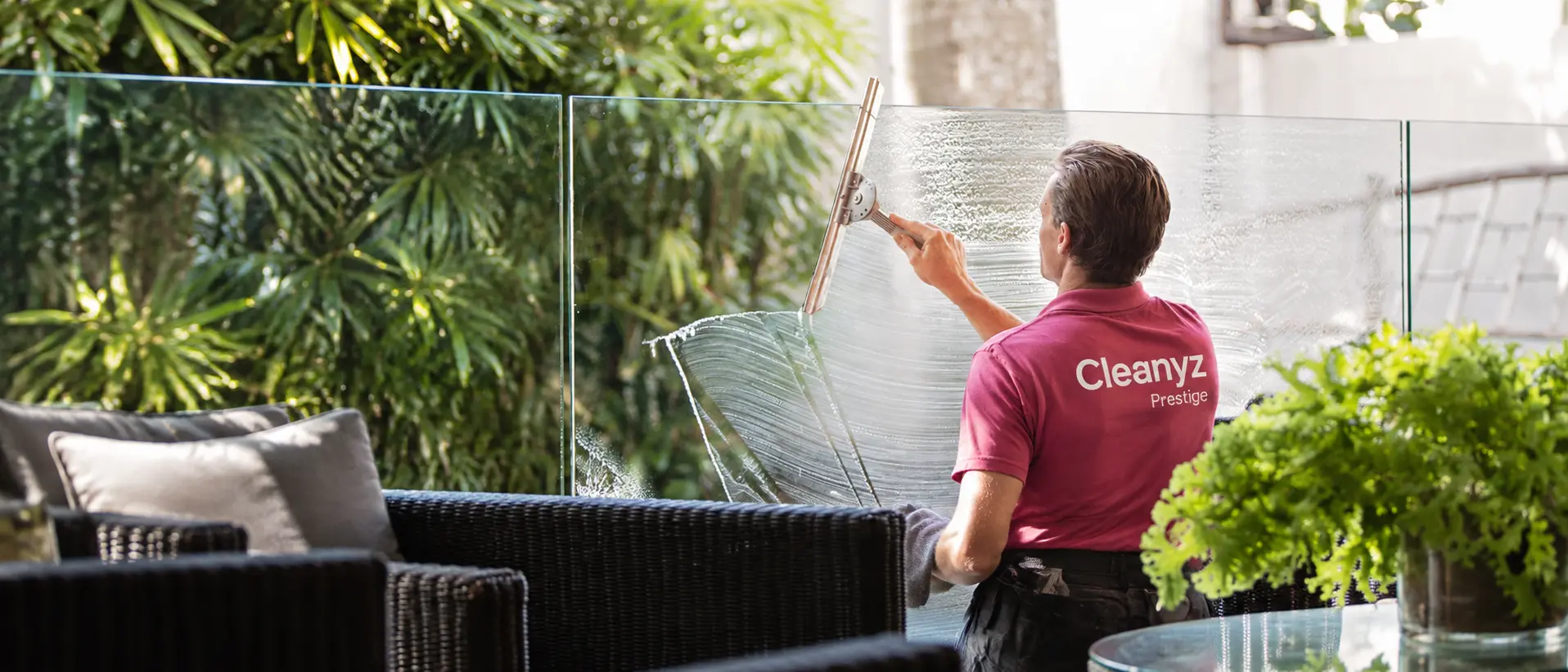 Professionnel Cleanyz Prestige nettoyant une paroi vitrée sur une terrasse